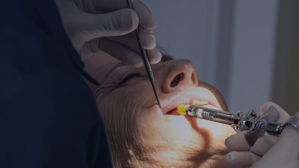 Dentista atendiendo a una paciente mayor en Clínica Dental Miriam García