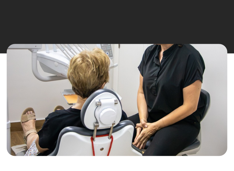 Dentista explicando el diagnóstico a una paciente en su primera visita